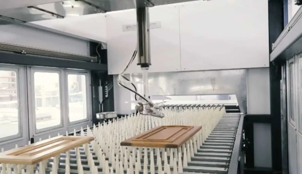 Robot de pintura industrial automatizado aplicando acabado a puertas de madera en línea de producción
